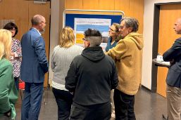 Teilnehmende des Gesundheitsforum stehen vor einer Pinnwand und sind im Austausch.